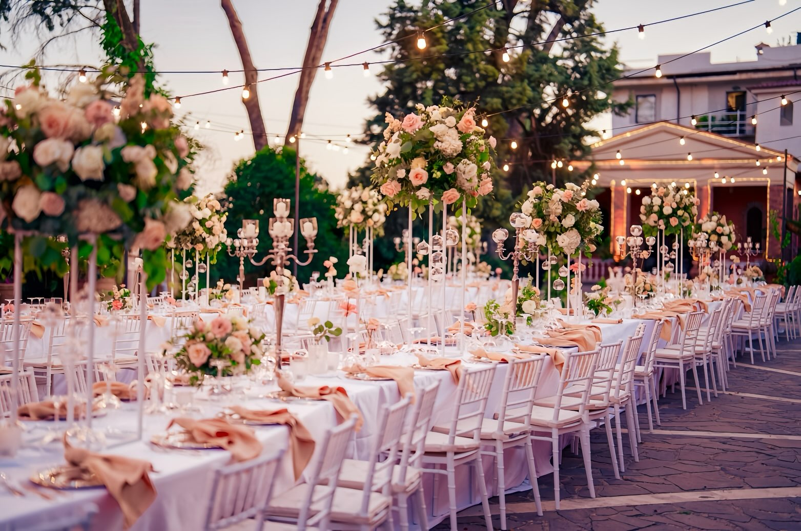 Tavolo imperiale allestito all'aperto con fiori rosa nei giardini di Villa Dafne Majestic