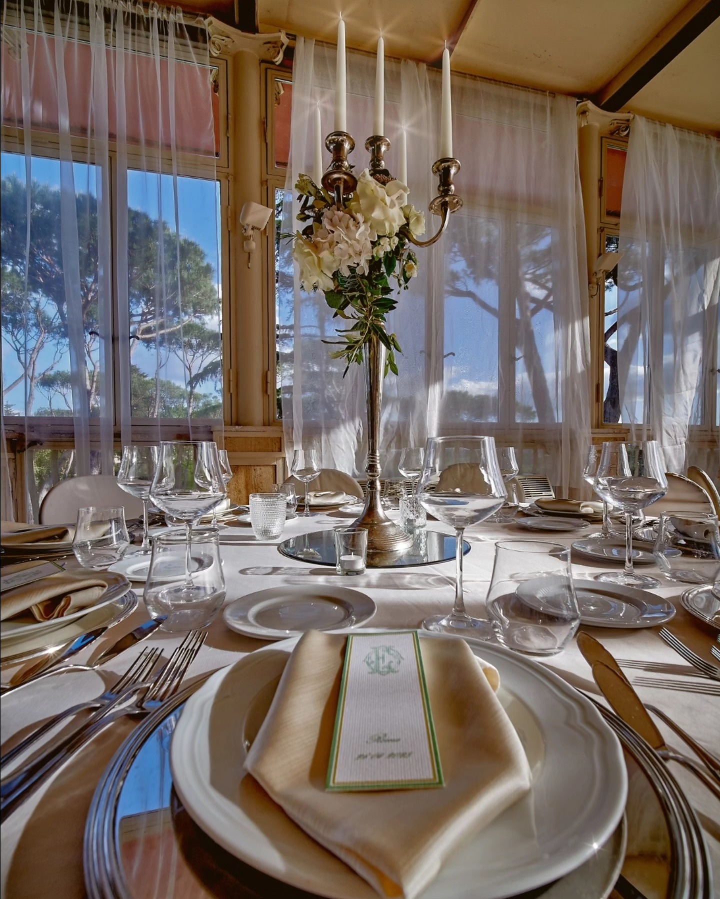 Mise en place della cena di gala a Villa Dafne Majestic: piatti, calici e candelabro Mise en place della cena di gala a Villa Dafne Majestic: piatti, calici e candelabro