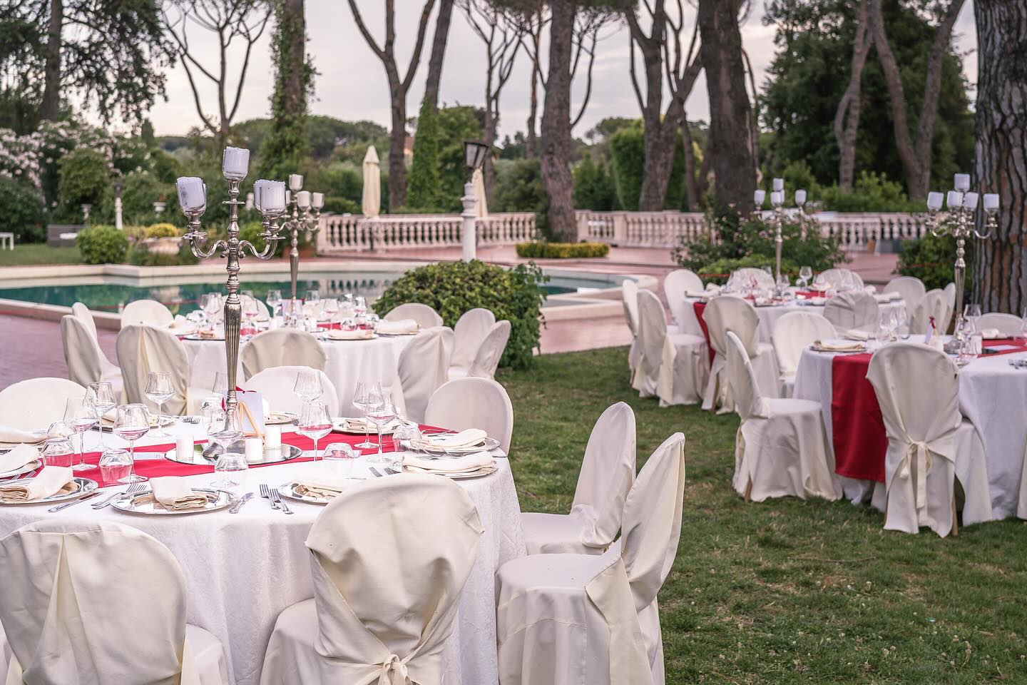 Panoramica dei tavoli rotondi allestiti nel giardino di Villa Dafne Majestic per un ricevimento di famiglia Panoramica dei tavoli rotondi allestiti nel giardino di Villa Dafne Majestic per un ricevimento di famiglia