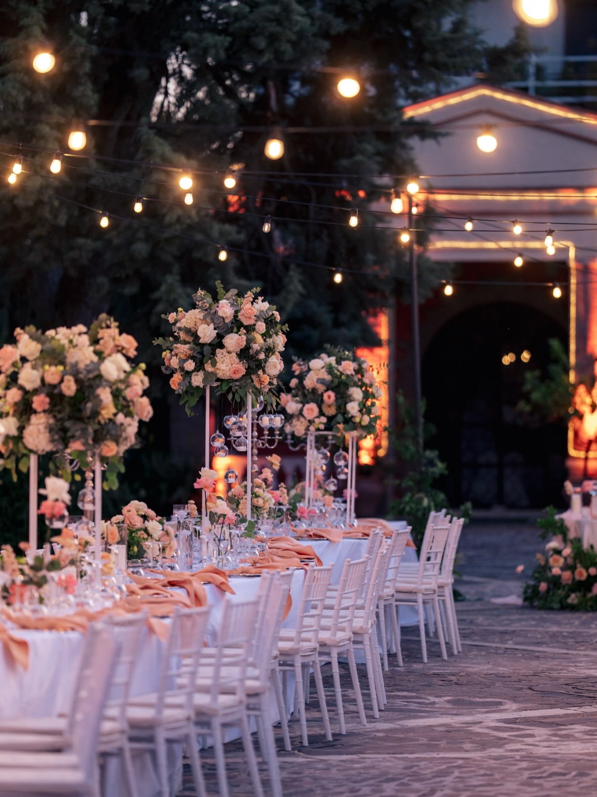 Tavolo imperiale allestito all'aperto con luci serali per un matrimonio a Villa Dafne Majestic Tavolo imperiale allestito all'aperto con luci serali per un matrimonio a Villa Dafne Majestic